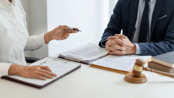 Image J'EMPRUNTE J'ASSURE - "Un bureau avec deux personnes en tenue professionnelle assissent à côté"